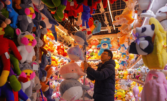 A market stall displaying a wide selection of plush toys in different designs and sizes