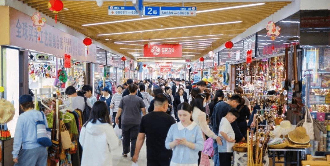 Buyers exploring an indoor Yiwu market aisle lined with wholesale displays